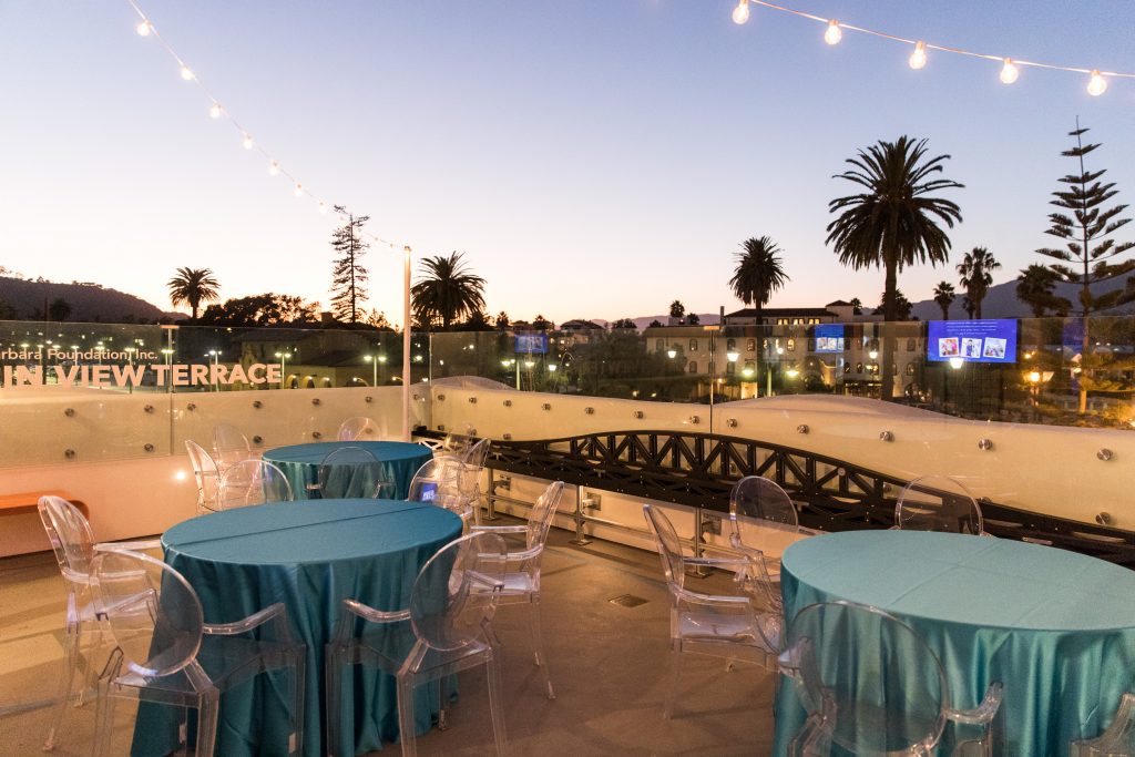 Mountain View Terrace - teal tables with ghost chairs and string lights