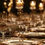 a lavishly decorated table set for a themed celebration, featuring elegantly arranged party-ready tableware and luxurious linens under warm, ambient lighting to create an inviting atmosphere.