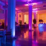 a sleek, elegantly decorated event space bathed in ambient, colorful lighting creates an inviting atmosphere for a sophisticated private gathering.