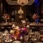 an elegantly arranged event space, adorned with sophisticated specialty décor rentals, showcasing a luxurious banquet table set with opulent centerpieces and atmospheric lighting that enhances the festive ambience.