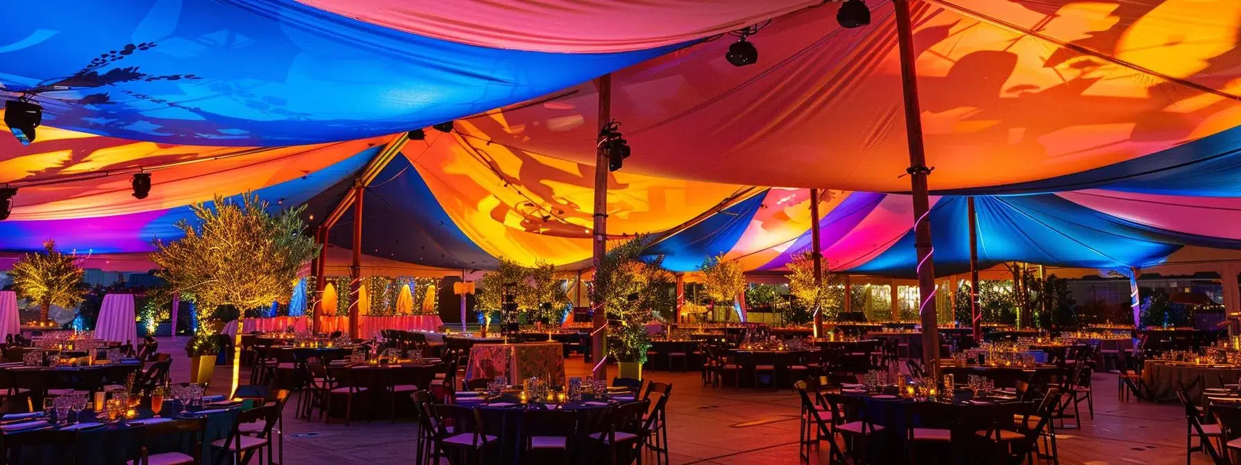 a meticulously organized event space showcases an effective tent layout, featuring clearly defined zones and strategic placement of furniture under vibrant canopies, illuminated by ambient lighting.