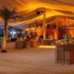 a modern event space showcases a diverse array of intricately designed tents, each styled uniquely to highlight their specific uses for various occasions, illuminated by elegant ambient lighting to enhance the sophisticated atmosphere.