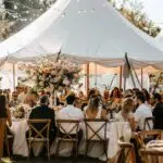 Outdoor wedding scene with guests enjoying comfort under a tent, showcasing climate control solutions
