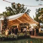 Outdoor wedding tent setup with guests in a garden setting