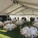Corporate tent rental setup at a business event with guests networking