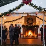 Outdoor holiday party tent setup with festive decorations and guests enjoying a winter celebration