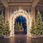 Stunning winter wonderland entrance with lighted arch and evergreen trees