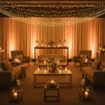 Warmly lit event space with amber uplighting and string lights creating an inviting atmosphere