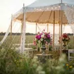Elegant wedding tent setup for ceremony with floral decor and ambient lighting