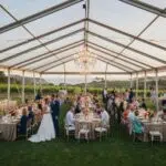 Outdoor wedding setup in Santa Barbara with clear tent and chandeliers, highlighting coastal views