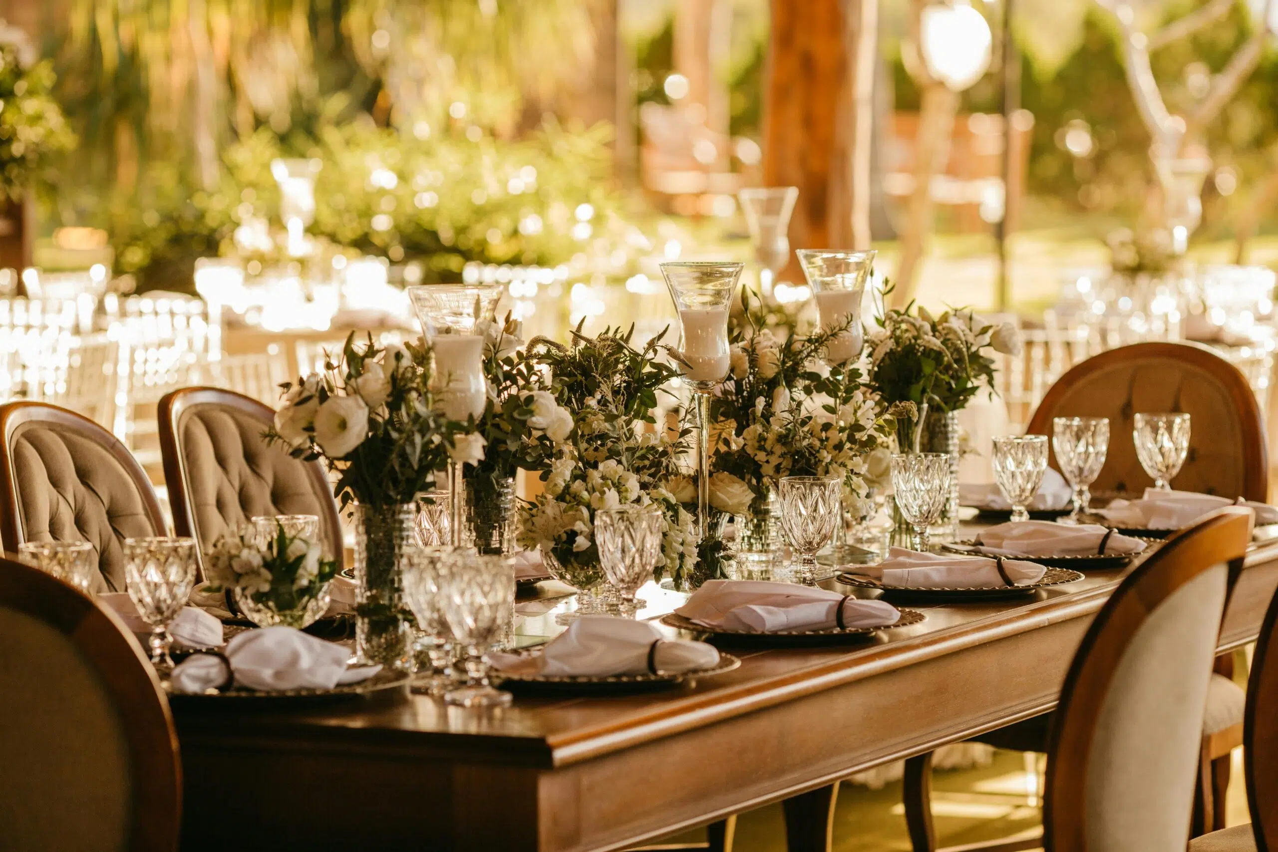 Elegant event table setting with floral centerpieces, crystal glassware, and neatly arranged plates, reflecting personalized decor for a memorable gathering in Southern California.