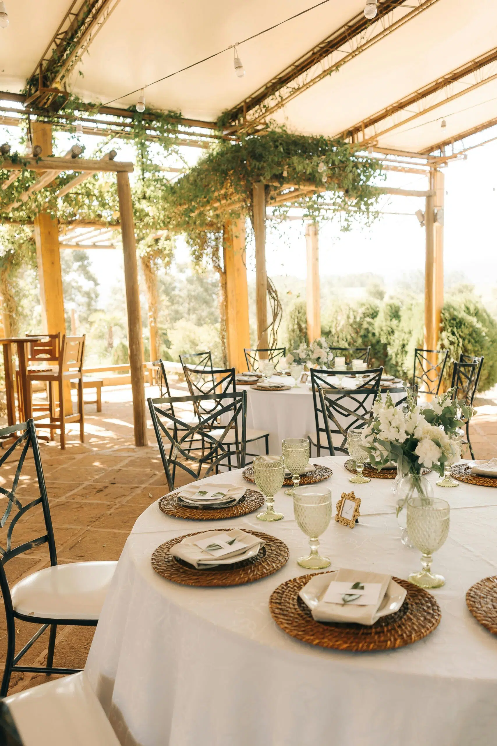 A table set for a wedding reception under an outdoor canopy