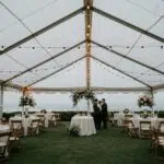 Elegant clear top wedding tent in a Ventura backyard with ocean views and floral decorations