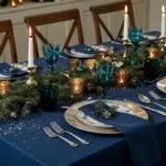 Elegant winter dining table with bold jewel-toned linens and metallic tableware