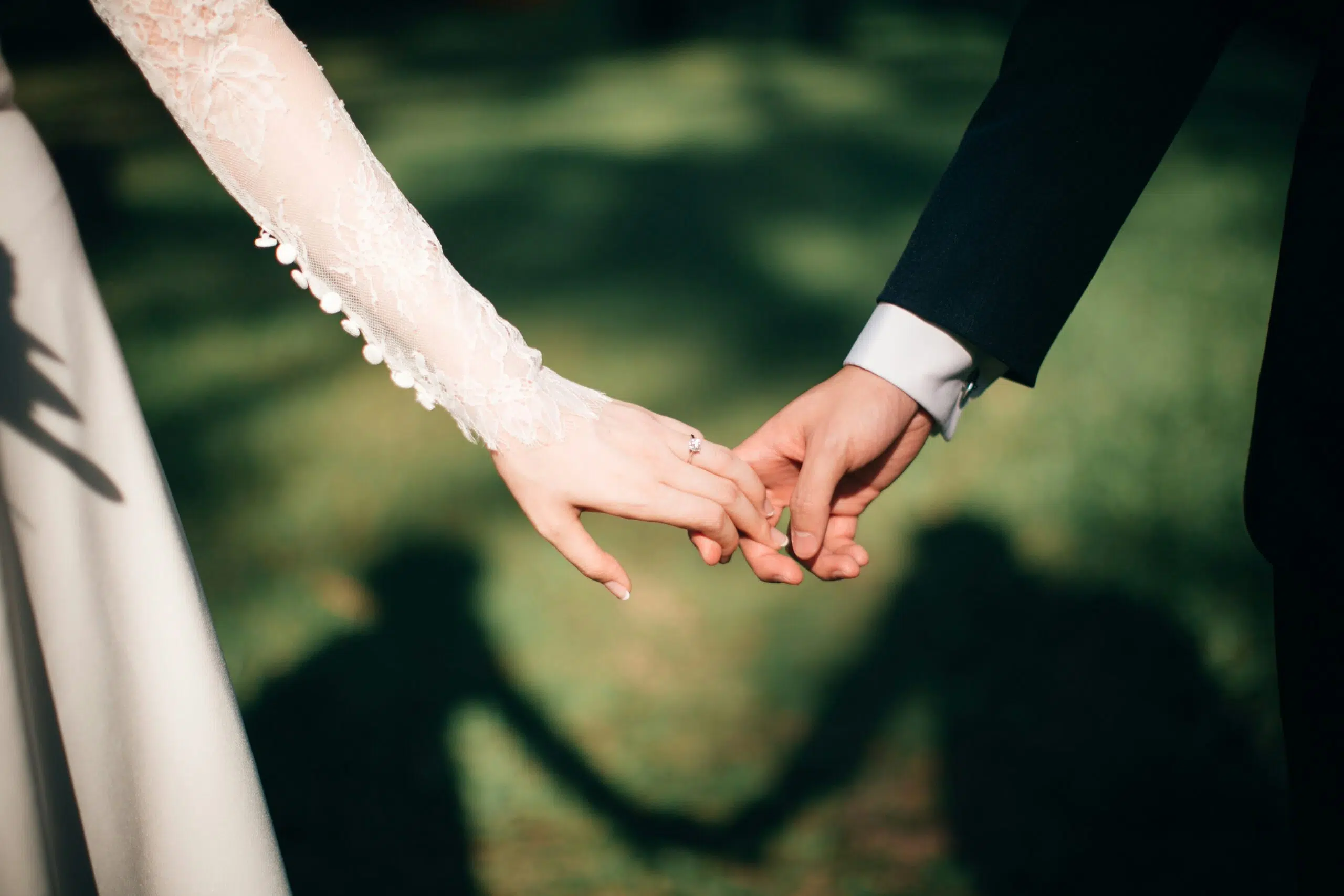 closeup of bride and groom holding hands