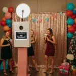 Festive holiday photo booth setup with guests enjoying the experience and colorful decorations