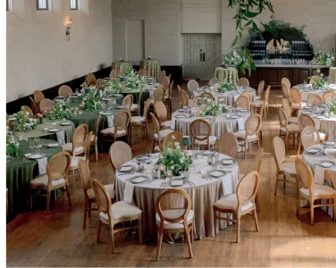 Elegant wedding reception setup at Hotel San Buena featuring round tables adorned with Olive Shantung Linen, Hand Woven Folding Chairs, and floral centerpieces, creating a romantic and inviting atmosphere.