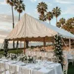 Elegant outdoor wedding tent setup in Santa Barbara with floral decorations and ocean view
