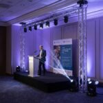 Professional corporate event lighting featuring adjustable spotlights and sophisticated uplighting to enhance a polished atmosphere