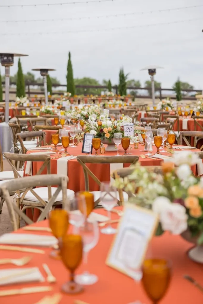 Formal Santa Barbara gala tablescape with coral linens, amber glassware, and floral centerpieces