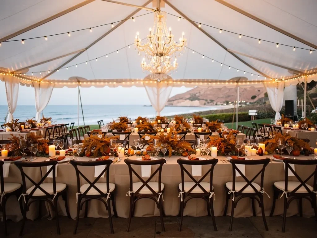 Luxury fall wedding under an elegant white tent with warm string lights and golden autumn