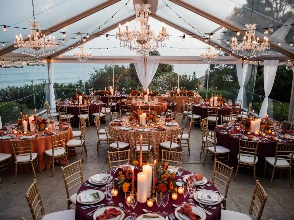 Luxury fall wedding reception inside an elegant tent with gold Chiavari chairs, rich linens, and