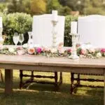 Wooden dining table, white chairs, floral arrangement